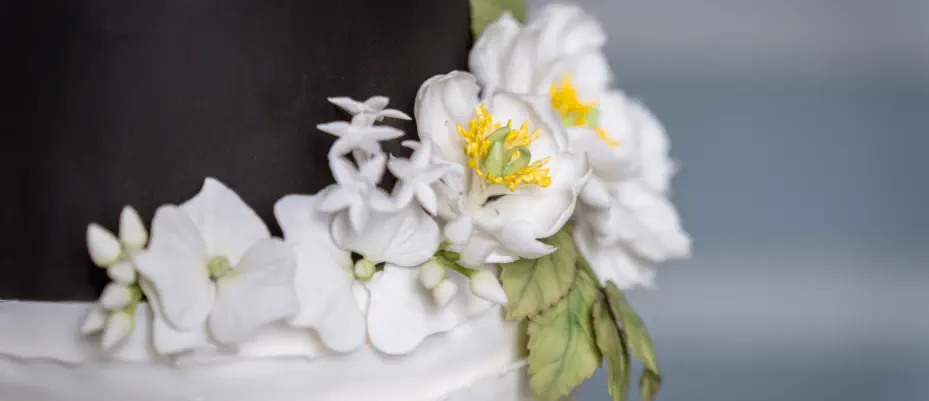 A lavish wedding dessert table adorned with popsicles, fudge, cupcakes, treats, macarons and more