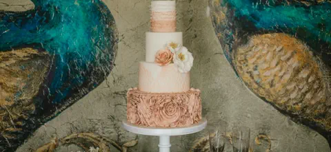 A lavish wedding dessert table adorned with popsicles, fudge, cupcakes, treats, macarons and more